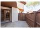 View of the patio area with wooden fence and access to home through sliding glass doors at 16402 N 31 St # 122, Phoenix, AZ 85032