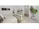 Modern bedroom featuring neutral colors, a decorative plant, and a white dresser with gold accents at 17165 W Corrine Dr, Surprise, AZ 85388