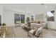 Bright living room with modern furniture, neutral colors, wood floors, and sliding door to the backyard at 17165 W Corrine Dr, Surprise, AZ 85388