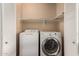 A dedicated laundry closet with a washer and dryer and shelf storage at 1753 E Pinto Dr, Gilbert, AZ 85296