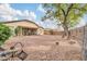 Large backyard featuring a rock covering, covered patio, and mature trees at 18033 W Carmen Dr, Surprise, AZ 85388