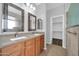 Bathroom with double vanity, granite countertop, and walk in closet access at 18033 W Carmen Dr, Surprise, AZ 85388