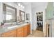 Bright bathroom with and sinks, tile floors, access to a walk-in closet, and modern finishes at 18033 W Carmen Dr, Surprise, AZ 85388