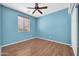 The bedroom is brightly lit, with modern wood flooring and a ceiling fan at 18033 W Carmen Dr, Surprise, AZ 85388