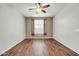 This bedroom features a ceiling fan and wood flooring, with a window providing natural light at 18033 W Carmen Dr, Surprise, AZ 85388