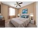 Staged primary bedroom with decorative pillows, lamps, and a ceiling fan at 18033 W Carmen Dr, Surprise, AZ 85388