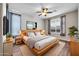 Modern bedroom with wood flooring, ceiling fan, large bed, and bedside tables at 18033 W Carmen Dr, Surprise, AZ 85388