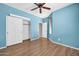 A bedroom with wood floors features a ceiling fan, and a closet at 18033 W Carmen Dr, Surprise, AZ 85388