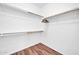 Walk-in closet featuring ample storage space with wooden floors and white walls at 18033 W Carmen Dr, Surprise, AZ 85388
