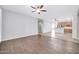 Spacious living room with hardwood floors and ceiling fans, flows into kitchen at 18033 W Carmen Dr, Surprise, AZ 85388