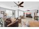 Bright living room featuring wood-look floors, ceiling fans, and large windows with plantation shutters at 18033 W Carmen Dr, Surprise, AZ 85388