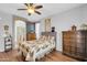 Comfortable main bedroom featuring wood floors, a ceiling fan, and an ensuite bathroom at 18033 W Carmen Dr, Surprise, AZ 85388