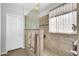 Tiled shower features a glass door, large window, and towel rack at 18033 W Carmen Dr, Surprise, AZ 85388