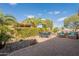 A landscaped backyard and patio area featuring a table and chairs, as well as outdoor seating with blue cushions at 1804 E Amaranth Trl, Queen Creek, AZ 85140