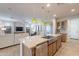 Spacious open concept kitchen with stainless steel sink, bar seating, and seamlessly connected living spaces at 1804 E Amaranth Trl, Queen Creek, AZ 85140