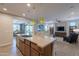 A kitchen island with a sink overlooking into an open concept living and dining area for entertaining at 1804 E Amaranth Trl, Queen Creek, AZ 85140