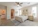 Spacious main bedroom features a ceiling fan, ensuite bathroom, and natural light from the windows at 1804 E Amaranth Trl, Queen Creek, AZ 85140