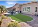 Beautiful backyard features a low-maintenance artificial lawn, desert landscaping, and outdoor seating area at 19765 N Swan Ct, Maricopa, AZ 85138