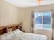 Cozy bedroom with plush bedding, side table, and natural light from the window at 19765 N Swan Ct, Maricopa, AZ 85138