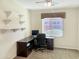 This bright bedroom includes a work area with a built-in desk, shelving, and neutral carpeting at 19765 N Swan Ct, Maricopa, AZ 85138