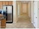 Inviting hallway with tile flooring that leads to a front door, kitchen with stainless steel appliances at 19765 N Swan Ct, Maricopa, AZ 85138