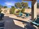 Covered patio with brick pavers featuring desert landscaping and comfortable seating arrangement at 19765 N Swan Ct, Maricopa, AZ 85138