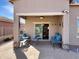 Covered patio features brick pavers, comfortable seating, and desert landscaping, providing a relaxing outdoor space at 19765 N Swan Ct, Maricopa, AZ 85138