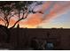 Backyard sunset featuring a custom outdoor sofa, desert landscaping, privacy wall, and a picturesque horizon at 2002 E Mitchell Dr, Phoenix, AZ 85016