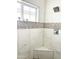 Bathroom shower with a window and pebble-style tile accent at 2002 E Mitchell Dr, Phoenix, AZ 85016