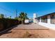 Expansive backyard featuring decorative rock, lush palm tree, string lights, and charming exterior of the home at 2061 E Bayberry Ave, Mesa, AZ 85204