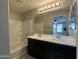 Bathroom showcasing double sinks, bathtub with white tile surround at 2107 N 77Th Dr, Phoenix, AZ 85035