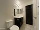 Bathroom with vanity and dark cabinets, tiled floor, toilet, and dark storage closet at 2107 N 77Th Dr, Phoenix, AZ 85035