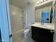 Bright bathroom featuring white tiled walls, a dark vanity, and a combined shower and tub at 2107 N 77Th Dr, Phoenix, AZ 85035