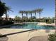 Community pool with palm trees, shade structures, water features, and seating at 2107 N 77Th Dr, Phoenix, AZ 85035