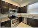 Kitchen with dark cabinets, granite countertops, and stainless steel appliances at 2107 N 77Th Dr, Phoenix, AZ 85035