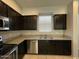 Kitchen features granite countertops, stainless appliances, and dark wood cabinets at 2107 N 77Th Dr, Phoenix, AZ 85035