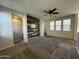 Open-concept living room featuring an accent wall, ceiling fan, and carpeted floors at 2107 N 77Th Dr, Phoenix, AZ 85035