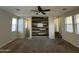 Open concept living room featuring a custom accent wall and a ceiling fan at 2107 N 77Th Dr, Phoenix, AZ 85035