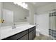 Bathroom featuring a large vanity with dark cabinets and a shower-tub combo at 214 N 190Th Dr, Buckeye, AZ 85326