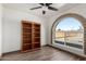 Bedroom featuring a bookcase, an arched window, and wood-look floors offering natural light at 22005 N 86Th Ave, Peoria, AZ 85383