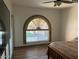 Cozy bedroom with wood-look floors and eye-catching arched window for natural light at 22005 N 86Th Ave, Peoria, AZ 85383