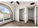 Bedroom features an arched window, sliding closet doors, and wood-look floors for modern living at 22005 N 86Th Ave, Peoria, AZ 85383