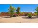 Expansive front yard with a circular driveway leading to a terracotta-colored home behind a fence at 22005 N 86Th Ave, Peoria, AZ 85383