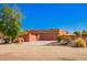 Southwestern-style home featuring a terracotta exterior, mature trees, landscaping and circular driveway at 22005 N 86Th Ave, Peoria, AZ 85383