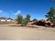 The exterior features mature trees, desert landscaping, with rock and desert sand yard at 22005 N 86Th Ave, Peoria, AZ 85383