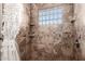 Walk-in shower featuring earth tone tile and a glass block window at 22005 N 86Th Ave, Peoria, AZ 85383