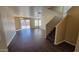 Large living room with wood-look flooring, featuring a staircase and sliding doors to the backyard at 22067 W Cantilever St, Buckeye, AZ 85326