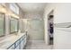 Bathroom featuring double sinks, a tiled glass shower, and convenient towel racks for a tidy space at 23219 N 145Th Dr, Sun City West, AZ 85375