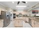 Bright kitchen features an island, tile floors, and stainless steel appliances at 23219 N 145Th Dr, Sun City West, AZ 85375