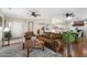 Open-concept living room showcasing a leather sofa, hardwood flooring, and access to the kitchen at 23219 N 145Th Dr, Sun City West, AZ 85375